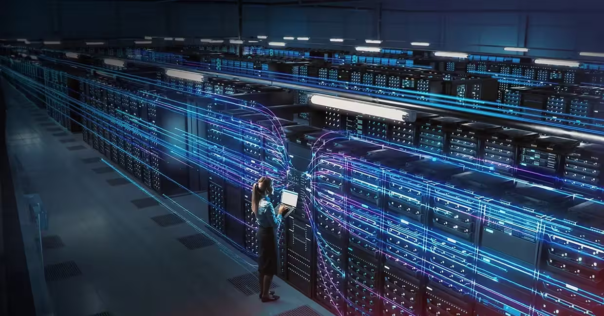 Woman standing in front of server racks with stylized arrows all converging on her.